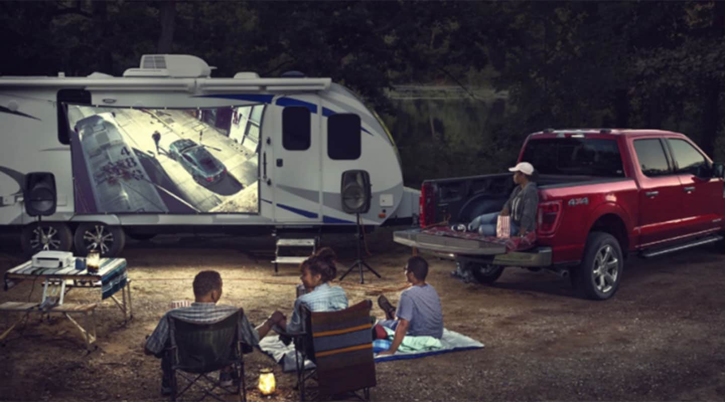 Ford F-150 Híbrida en color rojo protagonizando una escena familiar en un día de campo