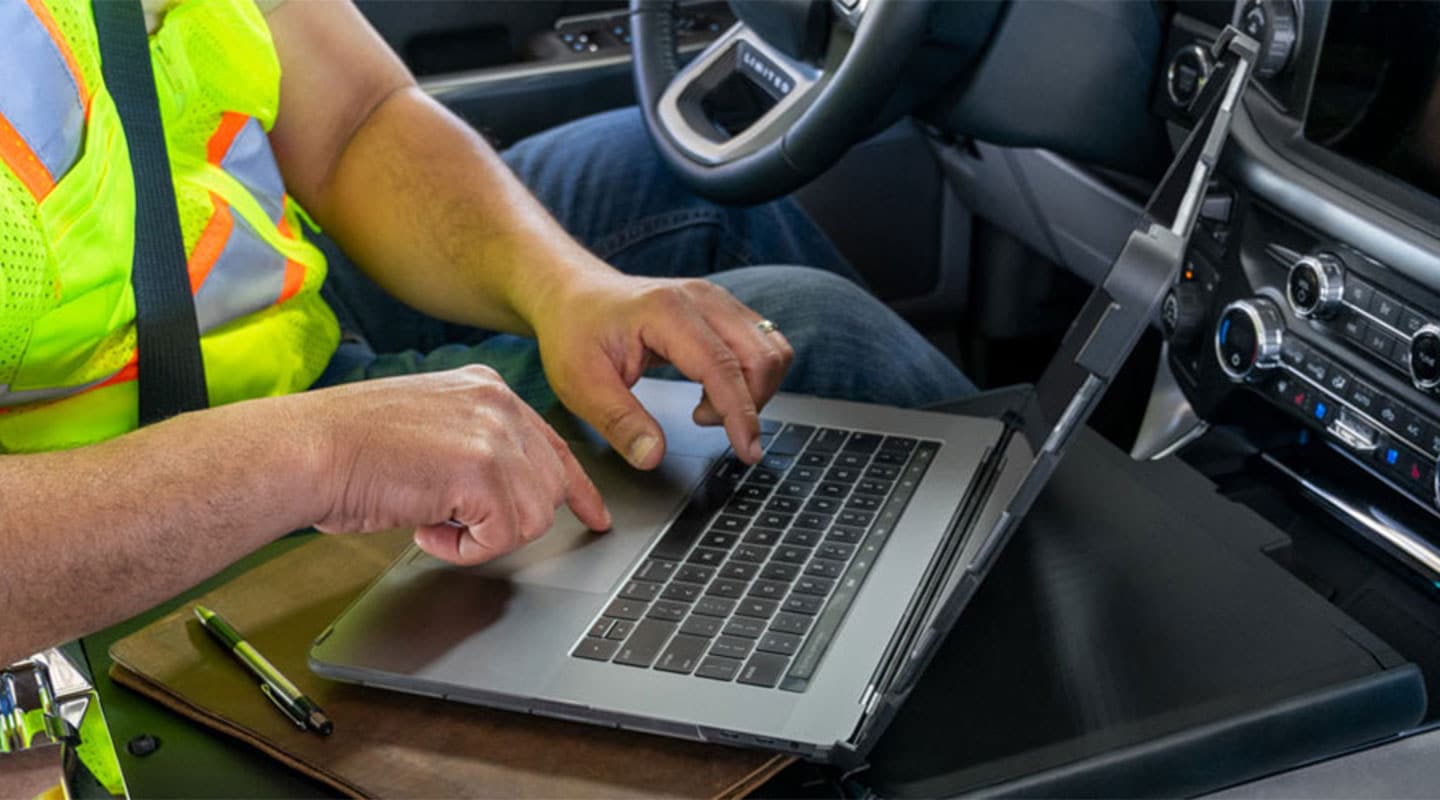 Una persona se encuentra trabajando con una laptop dentro de la cabina de una Ford F-150