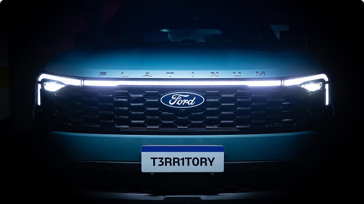 Vista frontal de la Ford Territory Platinum con luces LED encendidas sobre fondo oscuro.